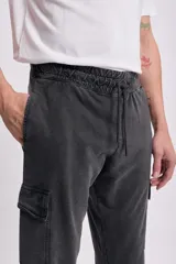 Pantalón deportivo cargo jogger negro con bolsillos laterales y tobillos ajustados.