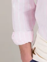 Camisa de hombre de corte regular fit, confeccionada en tejido oxford a rayas verticales celestes y blancas. Tiene cuello button-down, cierre con botones, manga larga con puño simple y logo bordado en el pecho.