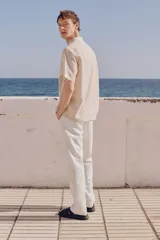 Pantalón blanco de lino y algodón, corte recto, con cintura elástica ajustable con cordón, bolsillos laterales y trasero.