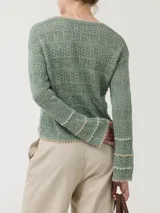 Sweater de punto calado color verde salvia, con cuello redondo y mangas largas acampanadas.
