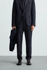 Pantalón de vestir azul marino, de corte recto, confeccionado en lino. Tiene bolsillos laterales y traseros con botón.