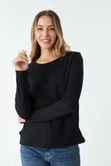 Remera negra de algodón, de corte recto, manga larga y cuello redondo.
