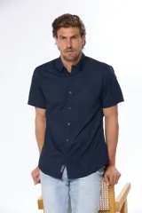 Camisa azul marino lisa de manga corta con cuello abotonado, cierre frontal con botones y bolsillo en el pecho. Confeccionada en algodón.