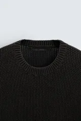 Jersey azul de punto con textura, corte holgado, cuello redondo y mangas largas.