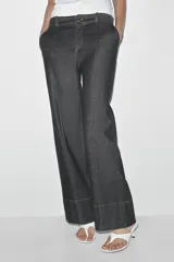 Pantalón de jean azul oscuro, de tiro alto y corte bootcut. Presenta bolsillos delanteros y traseros.