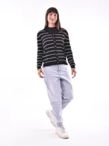 Cárdigan negro con rayas horizontales blancas, cuello en V y botones dorados.