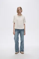 Blusa color coral con cuello redondo y mangas cortas con volados.