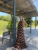 Vestido largo con estampado de zigzag en tonos beige y negro, con cuello halter y espalda descubierta.