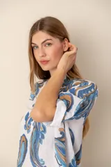 Vestido corto de lino color blanco con estampado de cachemir en tonos azul y marrón, cuello mao y mangas cortas con dobladillo.