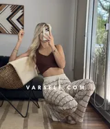 Pantalón de hilo color marrón con rayas horizontales blancas, corte holgado y cintura con cordón ajustable.