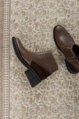 Bota corta color marrón con textura símil cuero de cocodrilo, caña baja, punta redondeada y taco cuadrado.