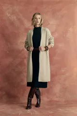 Saco largo tejido color beige, con cuello abierto y mangas largas.