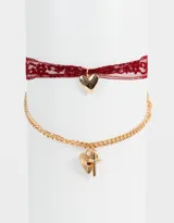 Set de dos collares cortos: uno con cinta de encaje color borgoña y dije de corazón dorado; otro con cadena dorada y dijes de corazón con textura y cruz con detalle de cristal rojo.