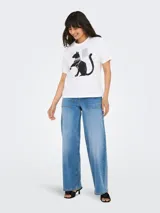 Remera blanca de algodón orgánico con cuello redondo y mangas cortas. Estampado frontal de un gato negro con collares de perlas y texto.