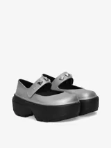 Zapatos Mary Jane metálicos con suela exagerada, correa ajustable y dijes removibles en forma de tachuelas plateadas.