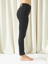 Pantalón de jean negro, corte skinny, tiro alto y largo al tobillo.