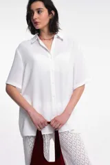 Camisa blanca de manga corta con cuello clásico y cierre frontal con botones.