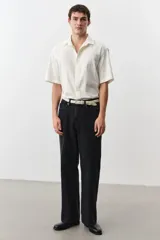 Pantalón de jean negro de corte recto y holgado, con tiro alto y cinco bolsillos.