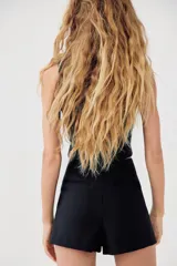 Falda pantalón corta negra de tiro medio con corte asimétrico.