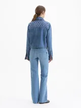 Jeans de mezclilla azul claro, tiro bajo, con corte ajustado en la parte superior y pierna recta que se ensancha ligeramente hacia el tobillo (skinny boot).
