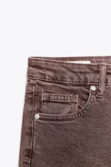 Pantalón de jean color marrón con efecto lavado, de tiro alto, corte cropped flare y cinco bolsillos.