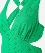 Vestido midi de algodón color verde esmeralda con diseño de laser cut y recortes en la cintura. Presenta escote en V profundo y tirantes finos que se cruzan en la espalda con esferas decorativas.