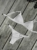 Conjunto de bikini turquesa con corpiño triangular de corte fijo, breteles regulables y almohadillas desmontables, y bombacha vedetina con frunce elástico en los costados.