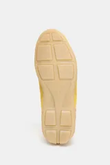 Zapatillas deportivas amarillas con detalles en negro y blanco. Presentan una combinación de materiales y texturas en el cuerpo, tirador en la lengüeta y cierre mediante cordones.