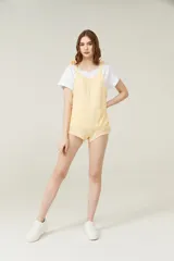 Mono color amarillo con tirantes ajustables y cinco bolsillos, ideal para el verano.