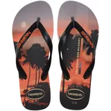 Ojotas Havaianas con base estampada con un paisaje de playa al atardecer y palmeras, tiras negras con el logo de la marca en color naranja.