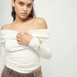 Pulsera elástica de hilo doble color naranja, con dije central de corazón dorado y un dije ovalado liso en la parte superior.