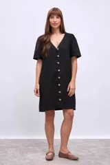 Vestido corto negro de lino con escote en V y abotonadura frontal.