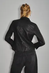 Camisa de cuero ovino color negro, de corte jeanero, con bolsillos tipo ojal en el delantero y cierre frontal con broches a presión con el logo de Rapsodia.