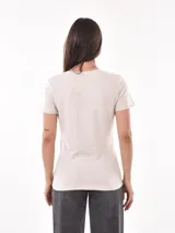 Remera negra de algodón con estampado frontal de la palabra "MERCI" en letras delineadas con colores del arcoíris.