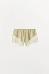 Shorts color beige de tiro alto confeccionado en tejido satinado con cintura elástica y detalle de encaje en el ruedo.