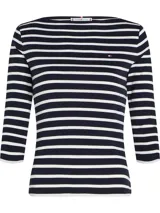 Remera Tommy Hilfiger de corte slim con cuello barco y mangas tres cuartos. Diseño a rayas horizontales azules y blancas con logo bordado en el pecho.