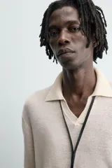 Sweater color crema de punto, con cuello polo y mangas largas. Tejido en hilatura de cáñamo con acabados en rib.