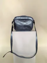 Bandolera de cuero color azul metalizado, con correa larga regulable, bolsillo frontal con fuelle y bolsillo trasero con cierre.