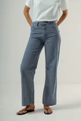 Pantalón de denim tiro alto, corte wide leg, color azul medio con estampado de pequeños lunares blancos.