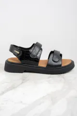 Sandalias negras con textura símil piel de cocodrilo, con ajuste de velcro y suela track.