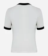 Remera corta blanca con cuello y mangas con ribete negro. Estampa frontal con la cantante Olivia Rodrigo, mariposas y corazones lilas.