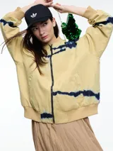 Campera bomber verde con estampado tie-dye en azul marino, cierre frontal y puños y cintura elastizados.