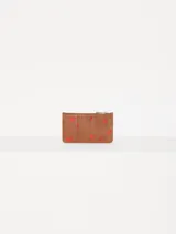 Tarjetero marrón de cuero vacuno liso con estampado de corazones rojos. Cuenta con bolsillo con cierre metálico, espacio para tarjetas y aplique metálico JCH en el frente.