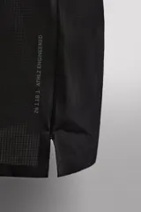 Musculosa deportiva negra de tejido ligero y elástico con zonas perforadas para mayor transpirabilidad. Cuello redondo amplio, sisa con acabados termofijados, bajo con aberturas laterales y logo estampado reflectante en la espalda.