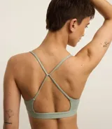 Top deportivo negro confeccionado en microfibra sin estampa, con espalda abierta y breteles finos cruzados.