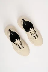 Zapatillas deportivas color beige con detalles en negro, de estilo chunky y suela track.