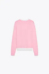 Chaqueta celeste de punto con cuello redondo y manga larga. Tiene cierre frontal con botones y detalle de falsos bolsillos delanteros con ribete blanco.
