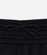 Pantalón deportivo negro de corte slim, con cintura elástica y bolsillos laterales.