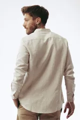 Camisa de lino color beige claro, de corte slim, con cuello mao y mangas largas.
