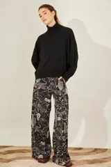 Sweater negro oversize de tejido de punto, con cuello alto y detalle de costuras a la vista.